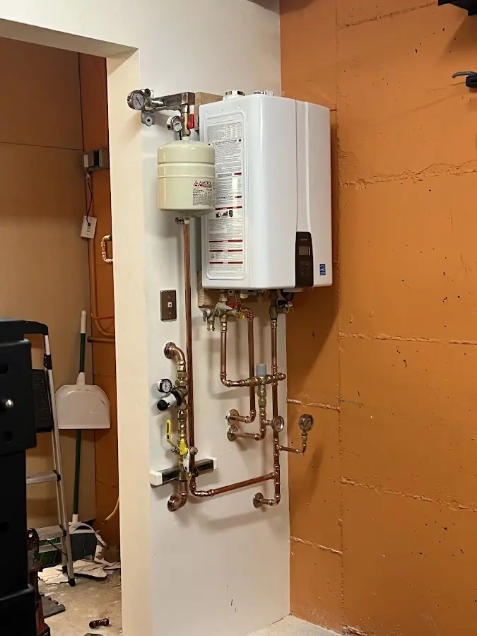 Plumbing technician inspecting water heater connections in Senoia